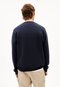 Marineblauwe sweatshirt met een ronde halslijn en ribgebreide manchetten. Gladde textuur, normale pasvorm en eenvoudig ontwerp zonder patronen of accenten.