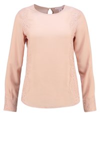 Blouse à manches longues rose clair avec col rond, bordure en dentelle le long des côtés et des poignets, et une petite ouverture en forme de trou de serrure au dos avec fermeture par bouton.