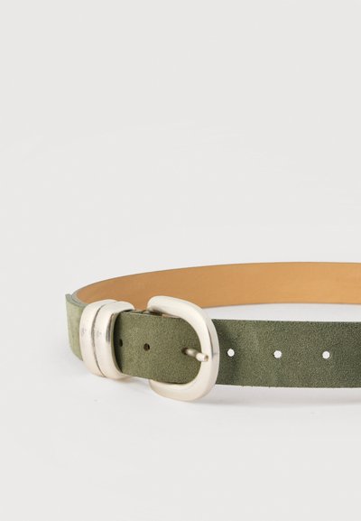 Ζώνη από suede δέρμα σε ελιά πράσινο χρώμα με στρογγυλό ασημί μεταλλικό αγκράφα και δύο αντίστοιχους ασημένιους κρίκους ζώνης σε λευκό φόντο.