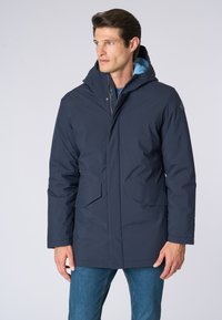 Cappotto imbottito blu navy con cappuccio regolabile, dotato di chiusure a scatto, due ampie tasche frontali e una fodera di un azzurro chiaro a contrasto.