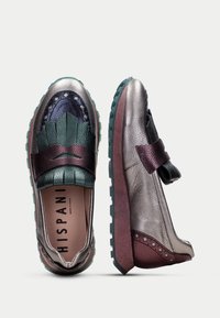 Scarpe in pelle multicolore con tonalità verdi, viola e argento; superfici texturizzate; design unico, con suole in gomma e dettagli decorativi.