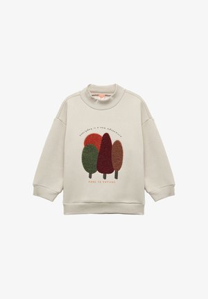 Lichtbeige sweatshirt met hoge kraag, met getextureerde geborduurde bomen in groen, rood en bruin. De tekst luidt "iedere dag is een nieuw avontuur."