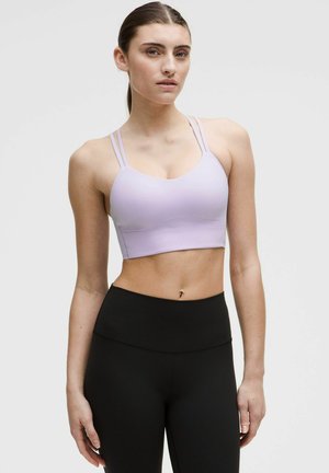 Soutien-gorge sport în culoare liliachie, cu bretele subțiri, duble și decolteu rotund, asortat cu colanți negri cu talie înaltă. Material neted, elastic la vedere.