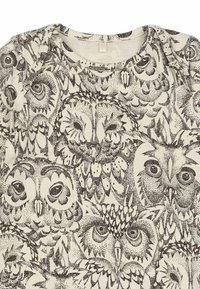 Baumwollhemd mit einem cremefarbenen Hintergrund und einem dichten, dunkelbraunen Eulenmuster. Runder Ausschnitt und kurze Ärmel. Detailreiches, abstraktes Design.