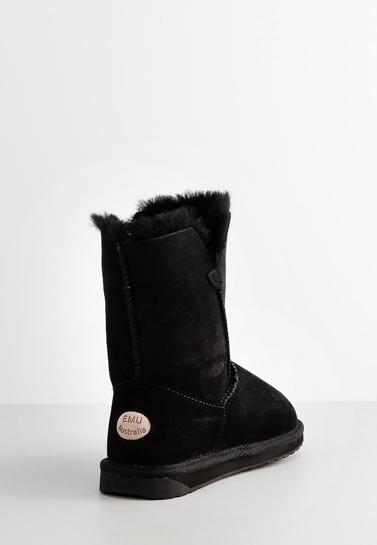 Botte d'hiver noire mi-mollet avec doublure en fourrure, extérieur en daim, semelle épaisse et étiquette beige "EMU Australia" sur le talon, présentée sur une surface blanche.