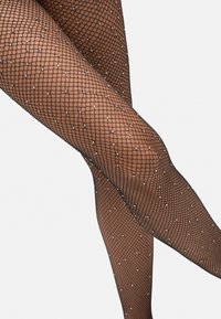 Pantys de red negra con un patrón de diamantes y gemas sintéticas incrustadas, destacando una apariencia texturada y acentos decorativos.