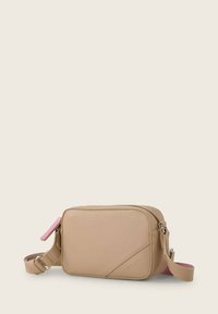 Bolso cruzado de cuero beige con diseño geométrico, cierre de cremallera y correa ajustable. Presenta un acento rosa en el tirador de la cremallera.