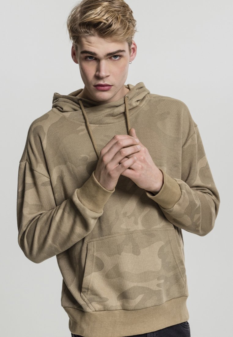 Beige színű kapucnis pulóver, álcázó mintával, kenguru zsebben és bordázott mandzsettákkal. Puha tapintású és laza illeszkedésű.