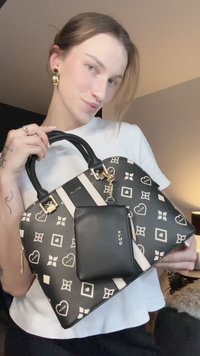 Musta-kermanvärinen kuvioitu käsilaukku, jossa kullanväriset metalliosat. Mukana irrotettava musta korttikotelo. Sileä pinta, pyöreä muoto, kaksinkertaiset kahvat.