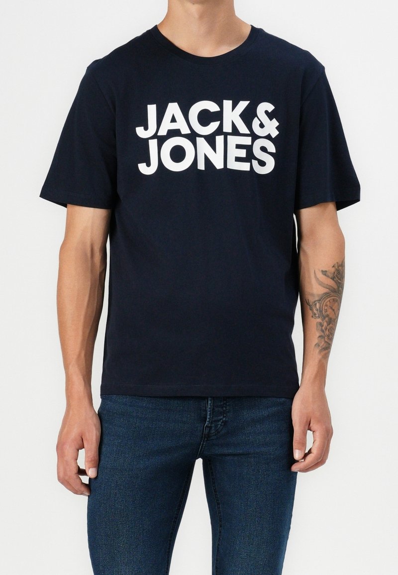 Camiseta de algodón azul marino de manga corta, con el gran texto blanco "JACK & JONES" en la parte frontal. Corte casual, textura suave.