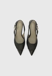 Schwarze Slingback-Absätze mit spitzen Zehen, aus Leder gefertigt, mit Netzdetails in Netzoptik und Schnallenbeschlägen am Knöchelriemen.