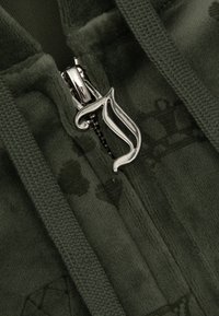 Green fleece zip-up hoodie featuring a silver zipper pull, textured fabric, and subtle patterned detailing on the chest area.