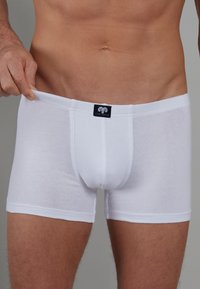 Weiße Boxershorts aus weichem Baumwollstoff, mit einem Logo am Bund, taillierte Passform und Oberschenkel-lange.
