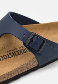 Sandalo Birkenstock blu navy con una cinghia testurizzata e una fibbia nera, plantare in sughero e suola in EVA nera.