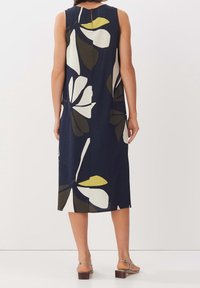 Hame vestido sin mangas de color azul marino con grandes patrones florales en blanco, verde y amarillo. De longitud media con corte recto y detalle de ojal en la parte trasera.