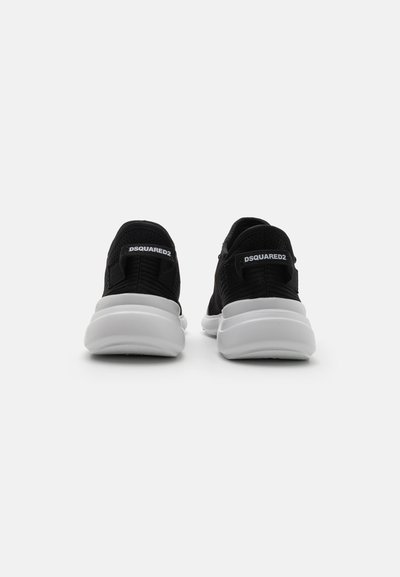 Black sneakers with a textured mesh upper, white midsole, and heel accents. Features branding on the back. Lightweight and modern design.