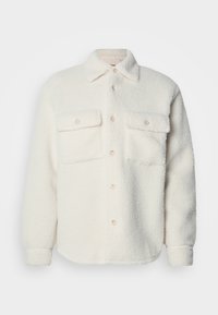 Ullent hvit skjortejakke med to brystlommer, frontknapplukking og klassisk krage. Myk tekstur og avrundet nederkant.