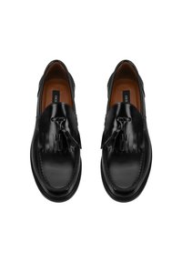 Zwarte leren loafers met een glanzende afwerking, voorzien van een franjesaccent aan de voorkant en contrasterende stiksels langs de zijkanten.