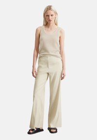 Lichtbeige, gebreide tanktop gecombineerd met lichtbeige, wijde broek; beide gemaakt van zachte stof, met een relaxte pasvorm en een minimaal design.