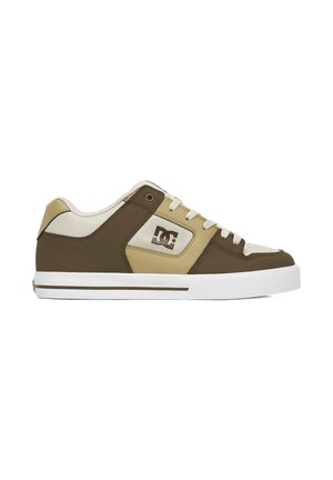 Sneaker basse beige e marrone con suola bianca, lacci frontali e logo DC sul pannello laterale.