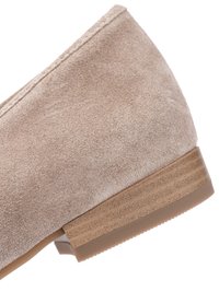 Beige suède schoen met gestikte bovenkant en gestapelde houten lage blokhak op witte achtergrond.