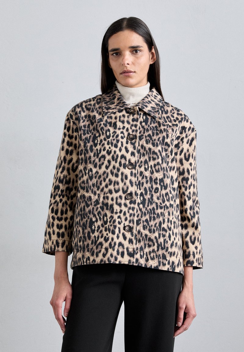 Bežinė ir juoda leopardo rašto striukė su klasikiniais apykaklėmis, mygtukų uždarymu ir trimis ketvirtadaliais rankovėmis. Minkšta tekstūra, laisvas siluetas.