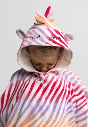 Dziecko w kolorowym, pasiastym ręczniku z kapturem z uszami zwierząt oraz detalami przedstawiającymi zamknięte oczy, patrzy w dół na jednolitym tle.