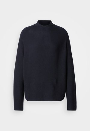 Merinoknitttrøye i marineblå med høy hals, lange ermer og løs passform. Myk tekstur, minimalistisk design og uten synlige logoer eller mønstre.