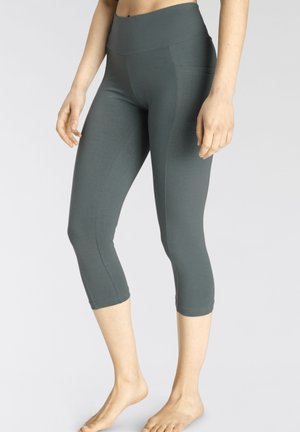 Capri-Leggings in Dunkelgrau, aus dehnbarem Stoff. Hoher Taillenbund, glatte Textur, taillierte Passform, die knapp unter der Wade endet.