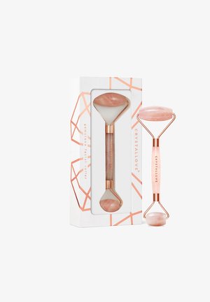 Różowa kwarcowa rolka do twarzy z polerowanym wykończeniem, wyposażona w podwójny koniec. Uchwyt wykonany z różowego złota, z wygrawerowanym napisem "CRYSTALLOVE".