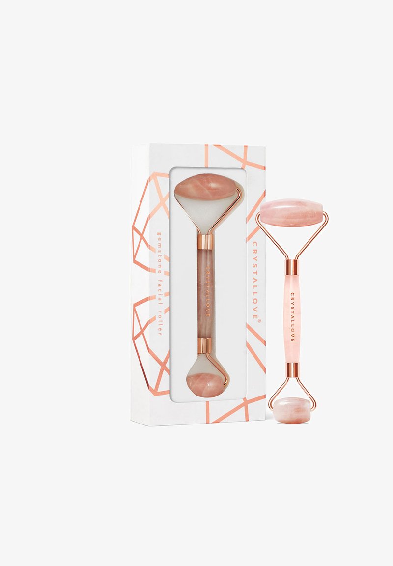 Różowa kwarcowa rolka do twarzy z polerowanym wykończeniem, wyposażona w podwójny koniec. Uchwyt wykonany z różowego złota, z wygrawerowanym napisem "CRYSTALLOVE".