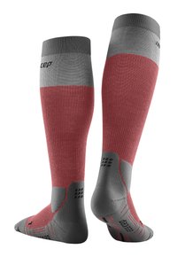 Calze compressive con una sezione inferiore rossa e una fascia superiore grigia. Presentano aree di grip in rilievo sulle suole e un logo sulla parte superiore.