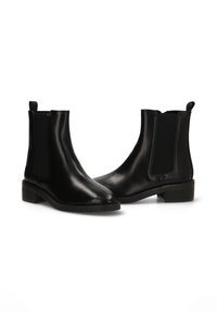 Botas Chelsea de cuero negro con paneles elásticos en los costados, punteras redondeadas, tacones bajos y tiradores para facilitar su uso. Textura suave en toda la superficie.