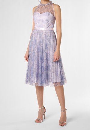 Sleeveless lavender midi dress with floral lace bodice, sheer neckline, satin waistband, pleated skirt, paired with silver high-heeled sandals.