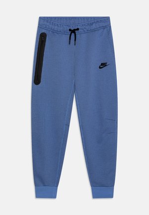 Blauwe sportbroek met een gestructureerd patroon, elastische tailleband, verstelbaar koord en een ritszak aan de zijkant. Zwarte logo-accent.