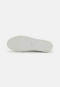 Talpă albă de pantof cu o suprafață texturată și un logo. Fabricată din cauciuc cu un model pentru aderență. Design curat și minimalist.