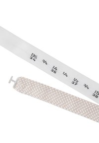 Maßband aus weißem Stoff mit schwarzen Markierungen für die Messungen, neben einem creamfarbenen gewebten Riemen mit einer silbernen H-förmigen Schnalle.