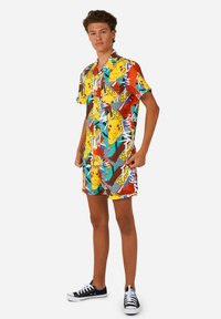 Chemise à manches courtes colorée mettant en vedette Pikachu et de bold motifs géométriques en jaune, rouge, vert et bleu. Design léger et décontracté pour le confort.