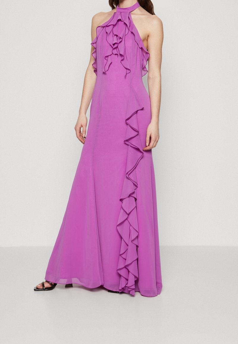 Robe longue à col licou en chiffon violet vif avec des détails volantés sur le devant et une jupe fluide. Bretelle réglable au cou.