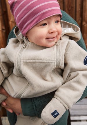 Beige fleecetrui met een ritssluiting aan de voorkant, voorzien van een capuchon en handschoenen, gedragen door een kind. Een roze gestreepte muts completeert de outfit.