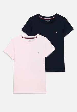 Deux t-shirts à col rond : un en rose pâle et un en marine foncé. Les deux sont en coton, avec un petit logo sur la poitrine et des manches courtes.