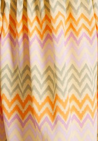 Tecido estampado com um design em zigzag em tons de laranja, lavanda, cinza e creme. Textura suave com efeito de aquarela.