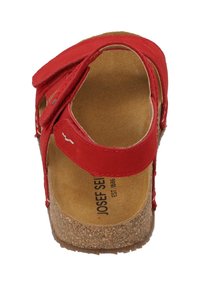 Czerwone sandały z dwiema regulowanymi paskami, korkową wkładką i teksturowaną podeszwą. Wewnątrz znajdują się beżowe wykończenie przypominające zamsz oraz logo marki.