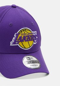 Purple baseball cap made of cotton with an embroidered "Los Angeles Lakers" logo and basketball graphic. Adjustable strap at the back.