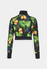 Lyhyet hihat, mustalla pohjalla ja eloisalla trooppisella painatuksella, jossa on vihreitä lehtiä, punaisia ja keltaisia kukkia sekä pitkiä lintuja.