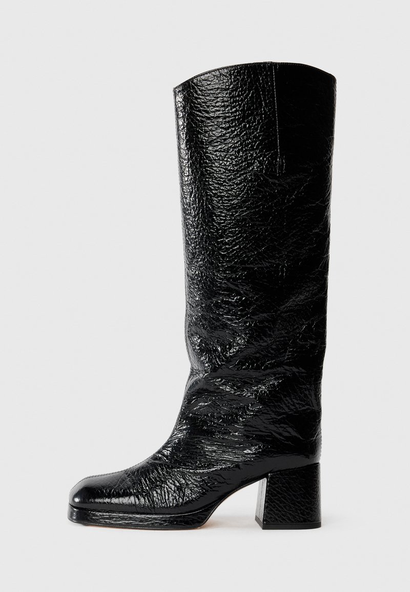 Bota negra hasta la rodilla hecha de charol texturizado con puntera cuadrada y tacón ancho. Acabado suave y brillante con detalles arrugados.