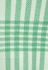 Zeleno-bílá látka se vzorem, která má vertikální pruhy a kostkovaný design. Měkká textura s různými odstíny zelené.