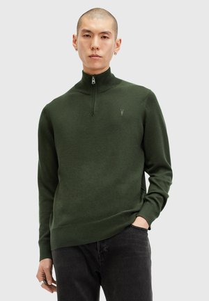 Maglione verde scuro, con collo alto e design a mezza zip, polsini a coste e un sottile dettaglio del logo sul petto. Realizzato in morbido tessuto a maglia.