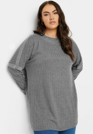 Grauer Langarmpullover mit geripptem Muster, verziert mit dekorativen Nieten entlang der Schultern und des Halsausschnitts. Lässiger Schnitt.