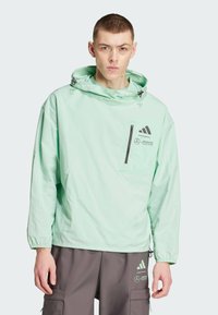 Miętowy, lekki polar z kapturem, z regulowanymi sznurkami, przednią kieszenią na zamek oraz czarnymi logo na piersi i rękawie.